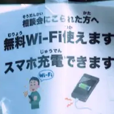 相談会場に掲げられた「無料Wi-Fi使えます／スマホ充電できます」の案内