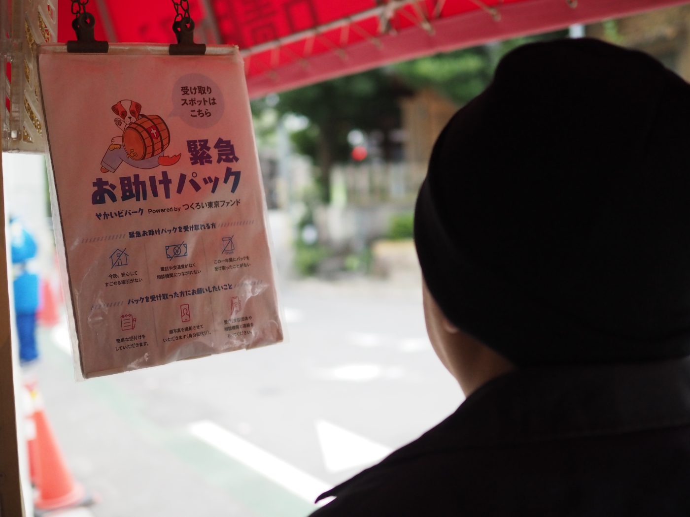 せかいビバークの受け取りスポットで緊急お助けパックの案内を見る人