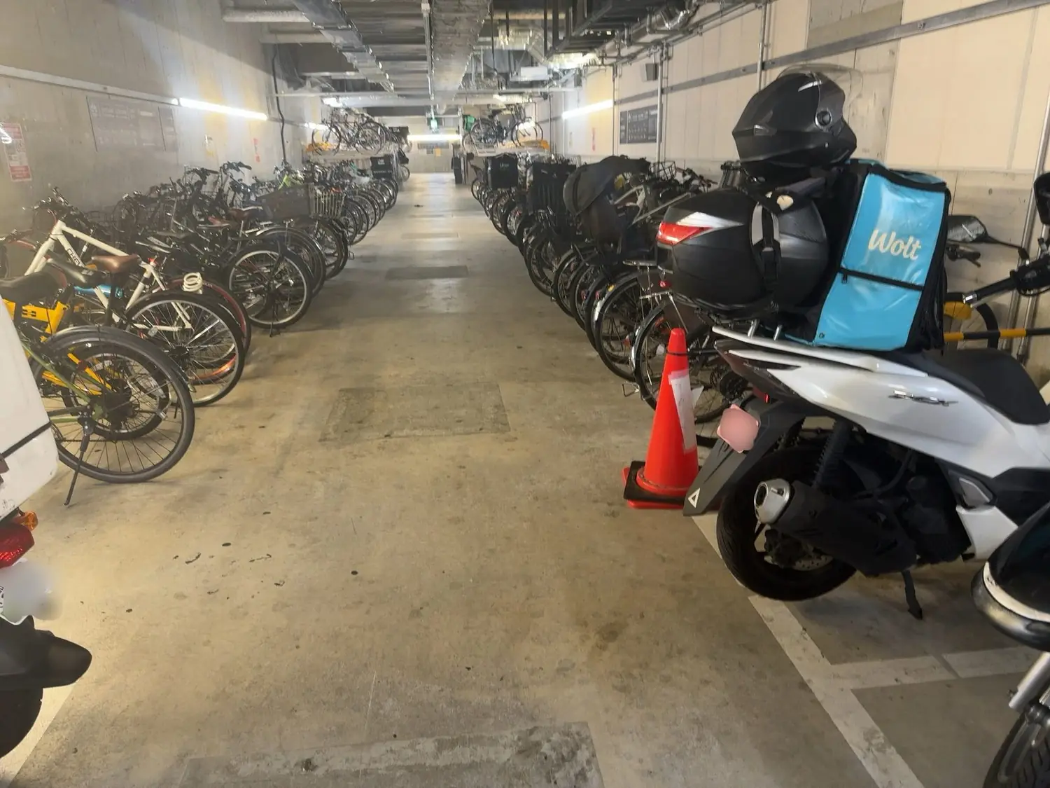 歌舞伎町の地下駐輪場。フードデリバリーのバッグを積んだ自転車とバイクが並んでいる