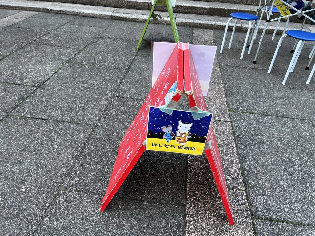 ほしぞら医療班のイラストが貼られた赤いA型看板