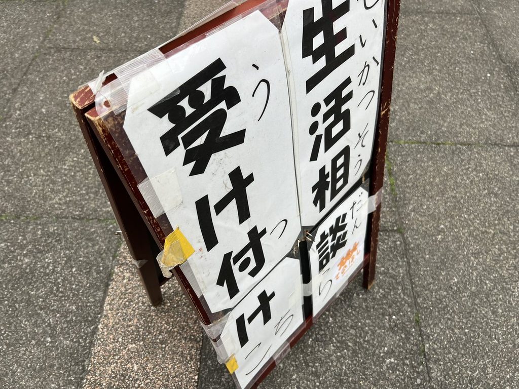 「生活相談 受け付けこちら」のA型看板