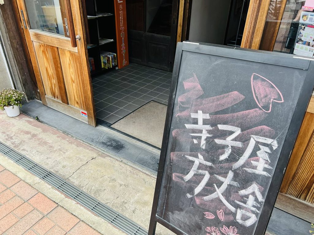 「寺子屋方丈舎」と書かれた立て看板と、建物の入口