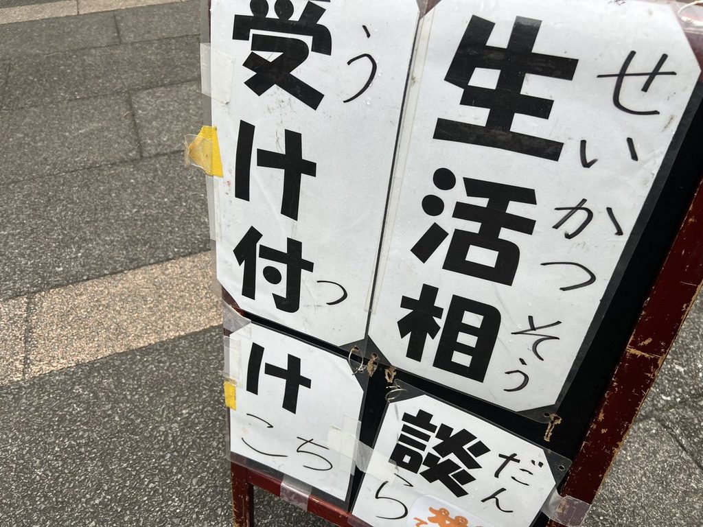 「生活相談 受け付け」のA型看板と黒板