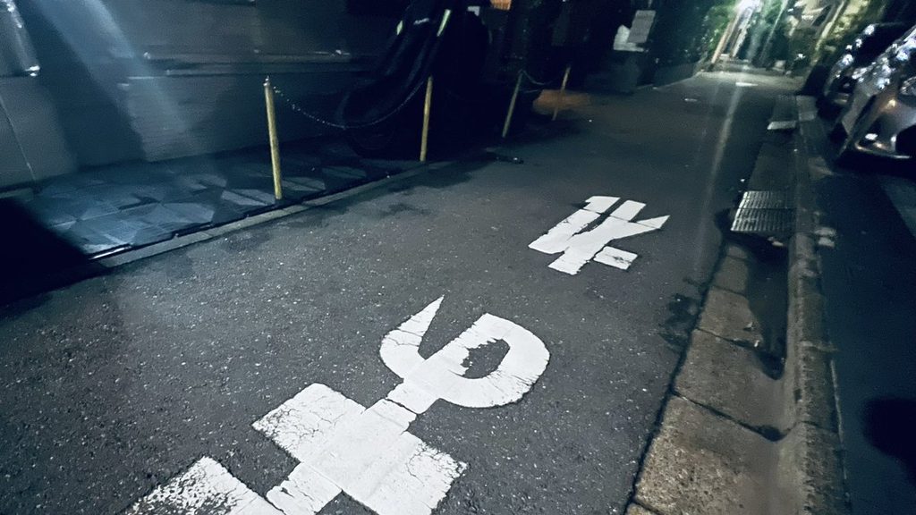 夜の路上に描かれた「止まれ」の文字
