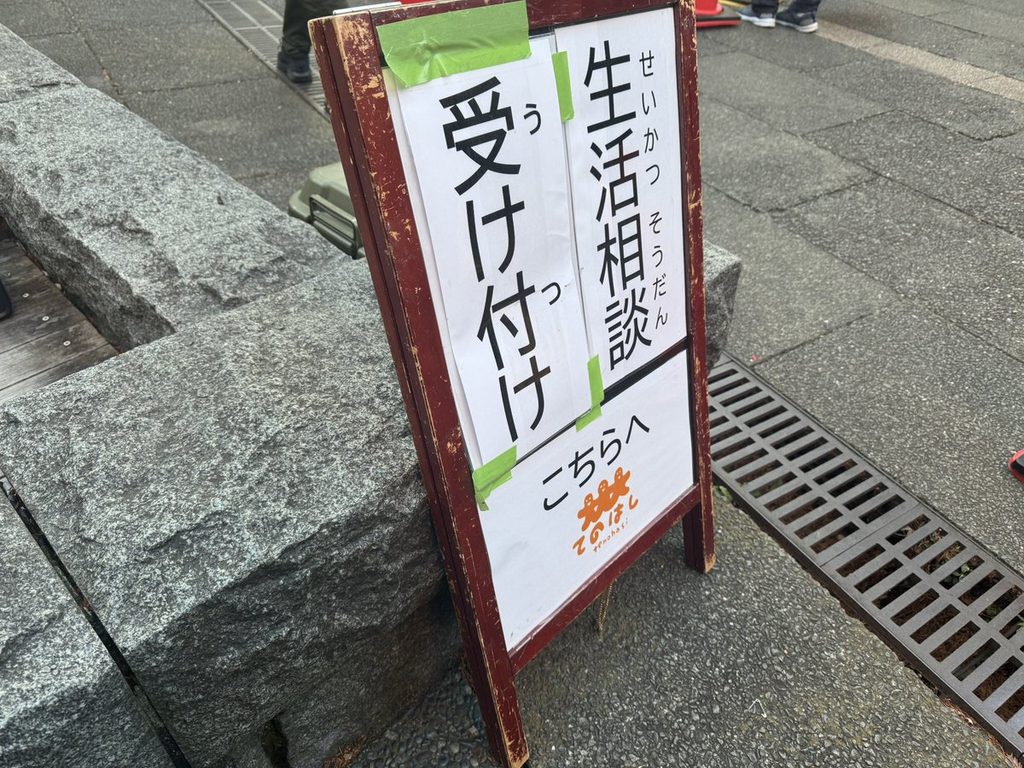 「生活相談 受け付け こちらへ」のA型看板