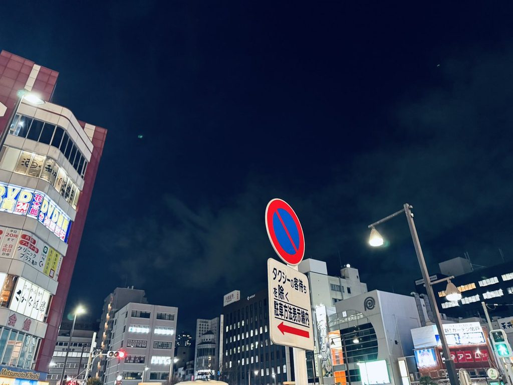 夜の街。ビルの明かりと道路標識