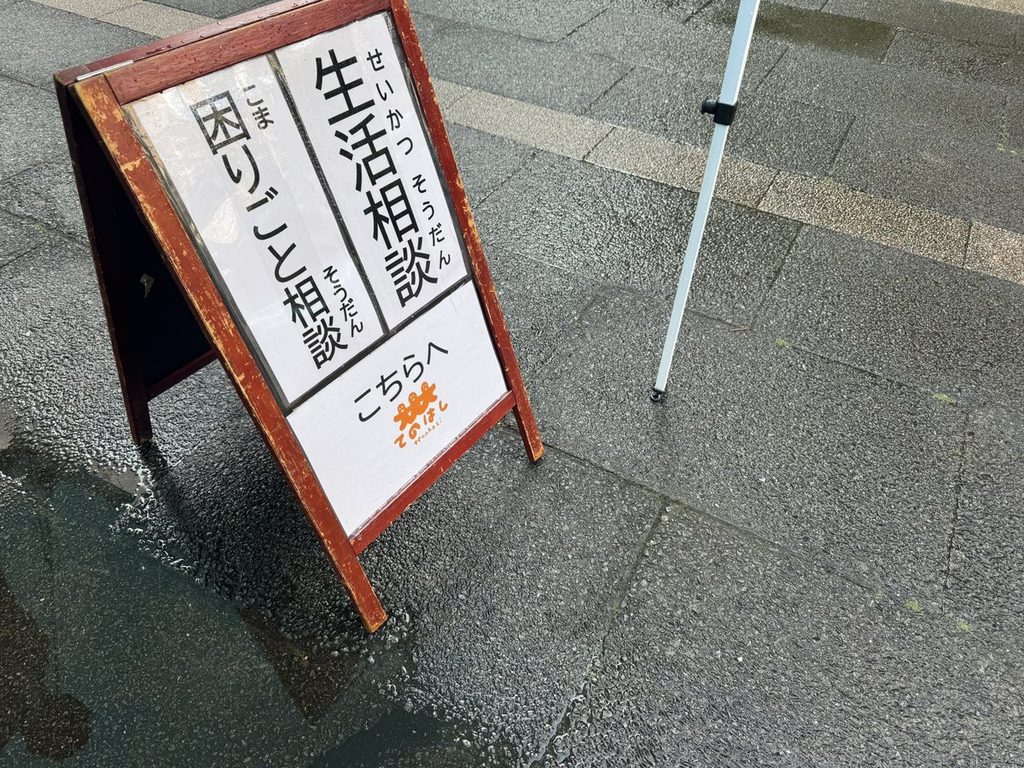 「生活相談 困りごと相談 こちらへ」のA型看板