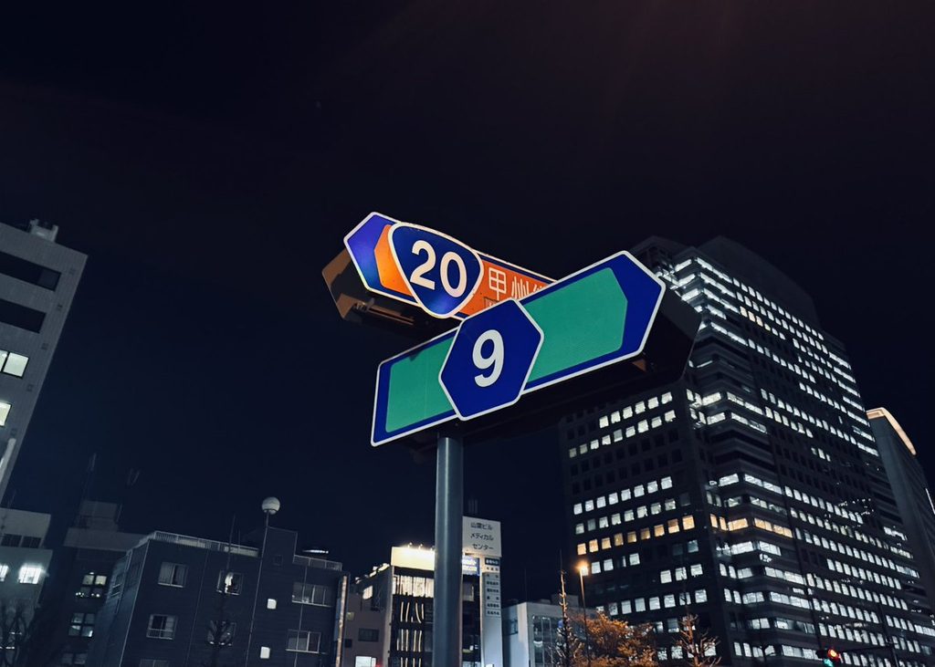 夜の道路標識とビル