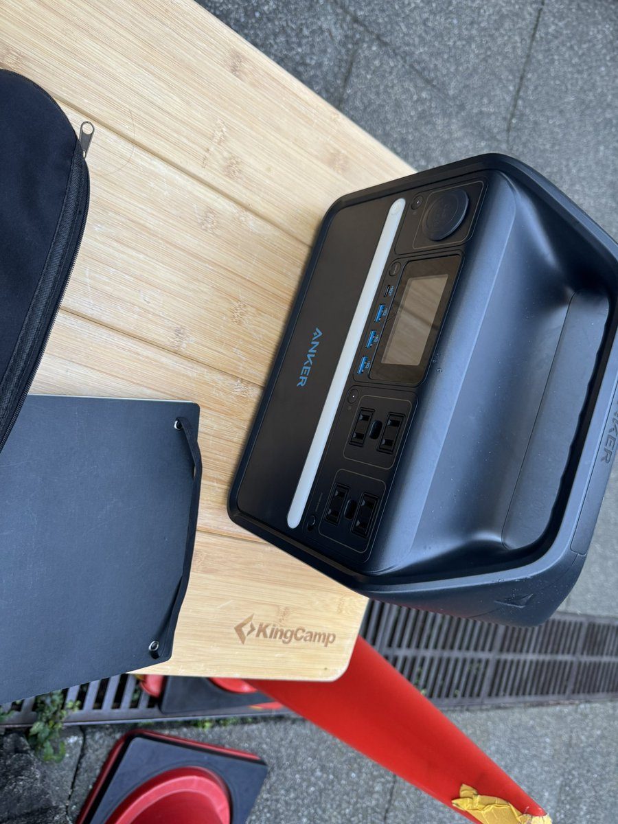 充電ブースの机の上に置かれたポータブル電源とかばん