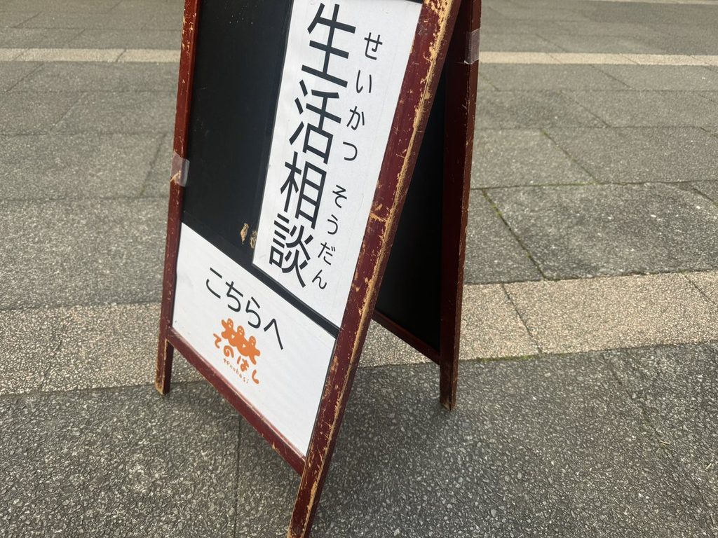 「生活相談 こちらへ」のA型看板