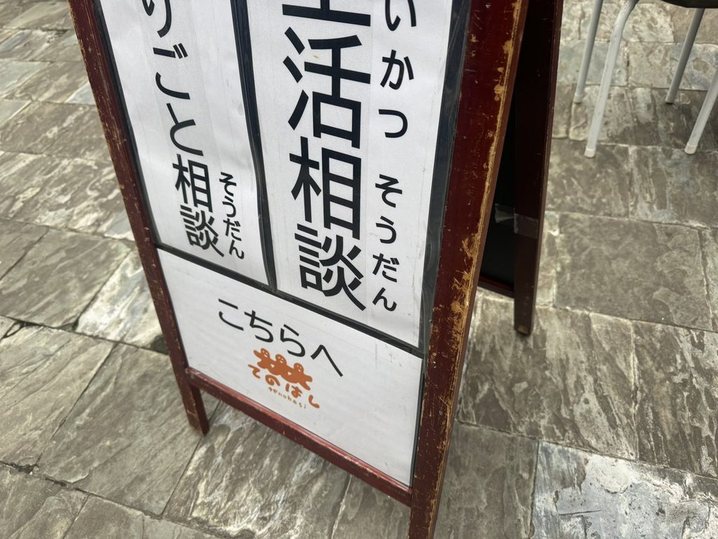 「生活相談 困りごと相談 こちらへ」のA型看板